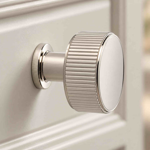 Close-up of 35mm polished nickel Lucia reeded cupboard knob showing ribbed edge and pedestal base
