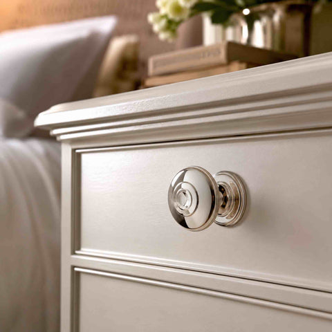 38mm polished nickel round reeded cupboard knob with decorative rose fitted to a cream painted bedside cabinet.