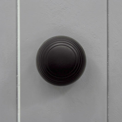 Black Sprung Beehive Mortice Door Knob Installed on a Grey Internal Door
