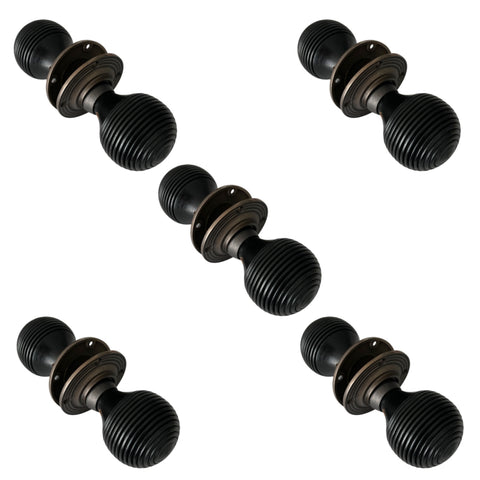 Set of five pairs of black ebonised beehive door knobs with matt antique backplates arranged on a white background