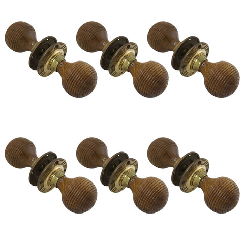 Six pairs of rosewood beehive door knobs with aged brass backplates arranged in rows.