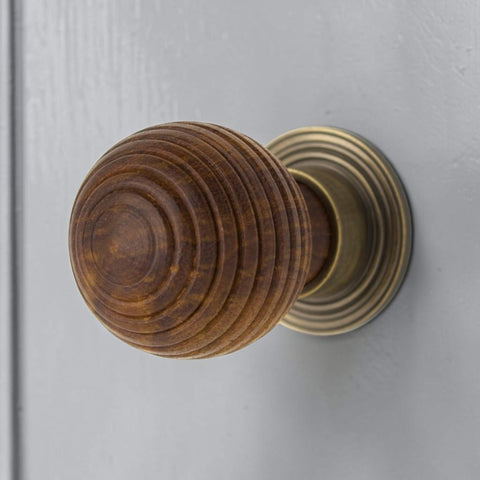 Front view of large rosewood beehive wooden cupboard knob fitted to a grey cabinet door