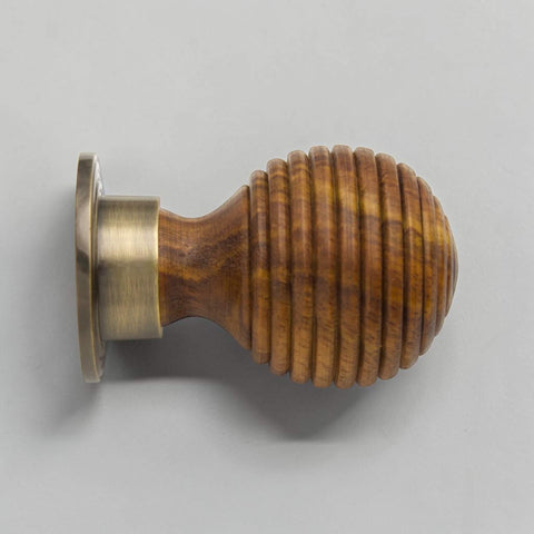 Side profile of large rosewood beehive wooden cupboard knob with antique brass backplate