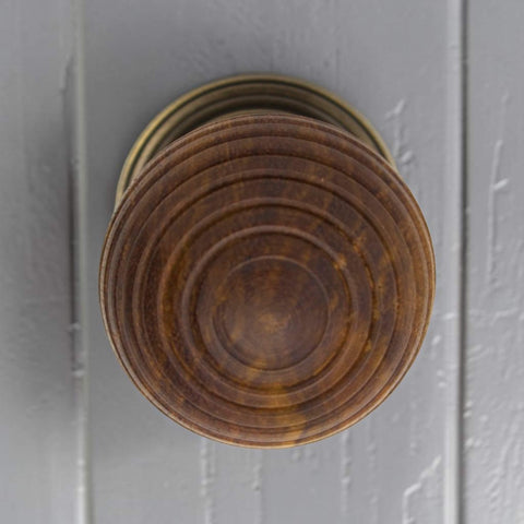 Top view of large rosewood beehive wooden cupboard knob installed on a grey cabinet door