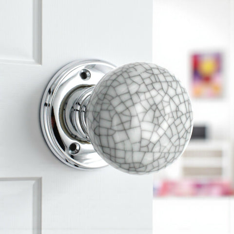 Blue crackle porcelain door knob installed on white door with polished chrome rose
