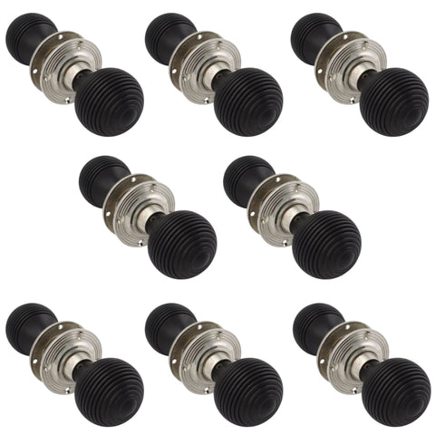 Eight pairs of ebonised beehive door knobs with polished nickel backplates arranged in rows.