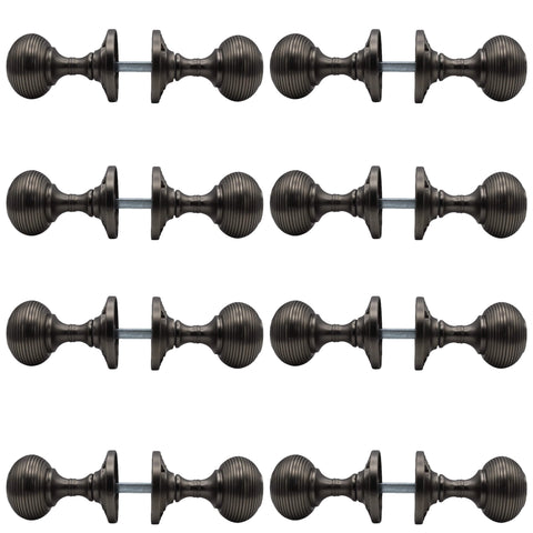 Set of 8 pairs of pewter sprung beehive mortice door knobs shown side profile with spindles fitted between backplates.