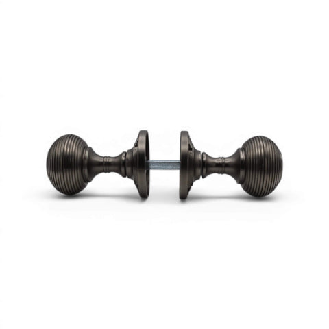 Side view of pewter sprung beehive mortice door knob pair connected by spindle, displaying traditional beehive shape.