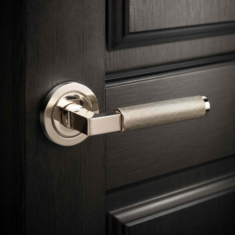 Polished nickel knurled door handle fitted to a black panelled internal door, showcasing the textured grip and modern round rose design.