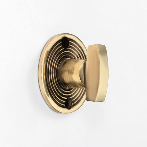 Angled View of Aged Brass Beehive Thumb Turn on Decorative Reeded Rose