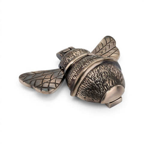 Unlacquered aged brass bumble bee door knocker, angled side view showing textured body and striking mechanism.