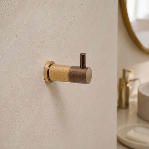 Aged brass hammered coat hook mounted on a wall