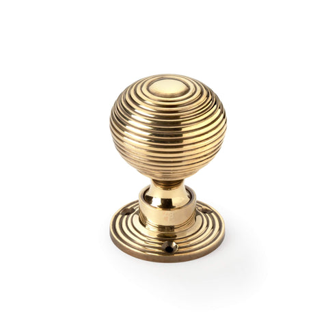 Single aged brass hollow beehive mortice door knob front view on white background