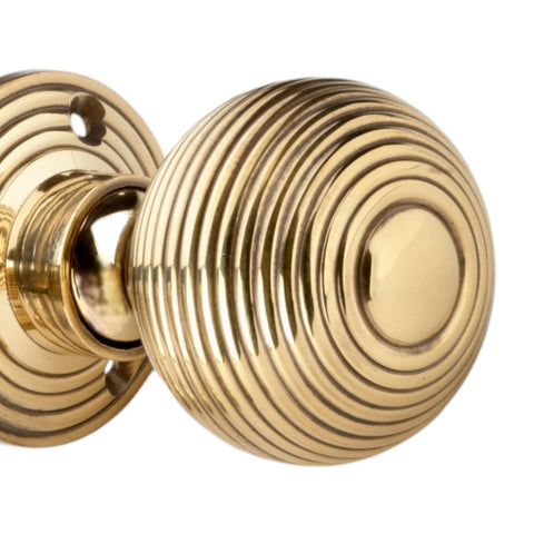 Detailed close-up of aged brass hollow beehive mortice door knob showing concentric ring design