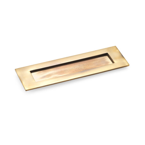 Aged brass Victorian letter box plate with sprung flap, rectangular design, photographed on a white background.