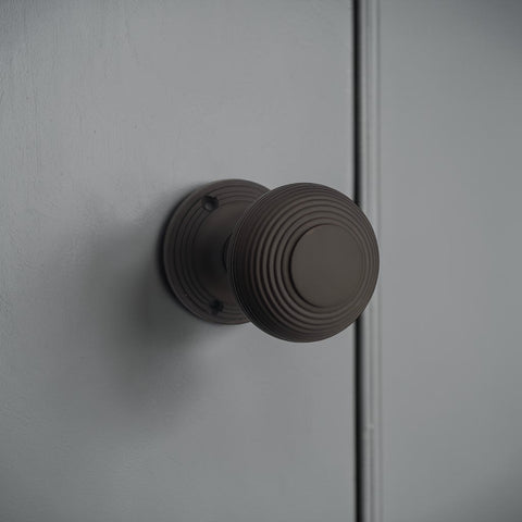 Aged bronze beehive mortice door knob installed on painted interior door