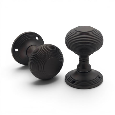 Aged bronze beehive mortice door knobs displayed together on white background