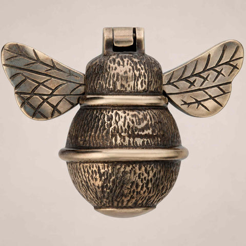 Aged brass bumble bee door knocker front view showing detailed wings and textured body design