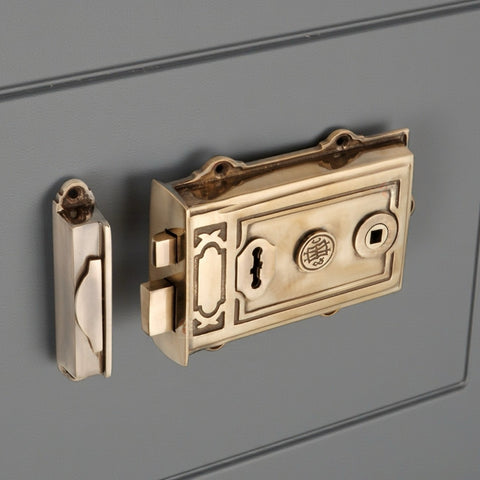 Aged solid brass Davenport Victorian rim lock fitted to a painted panel door with matching keep.