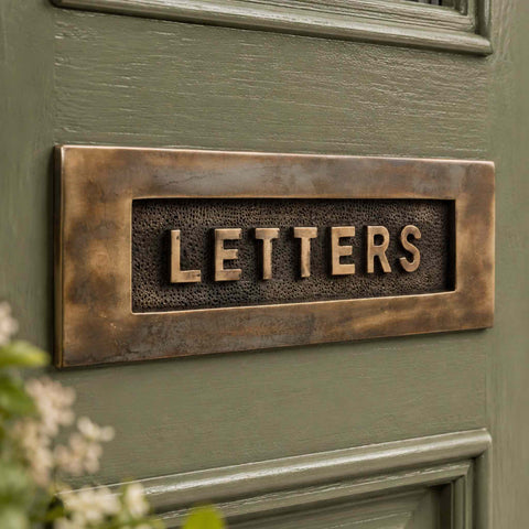 Close-Up of Aged Solid Brass LETTERS Letter Plate Showing Textured Background Detail