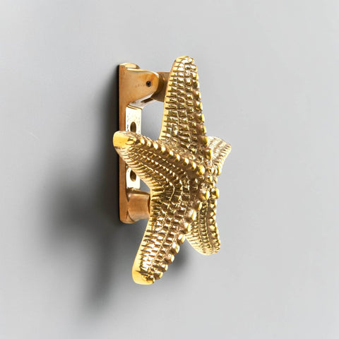 Aged solid brass starfish door knocker side profile showing mounting bracket