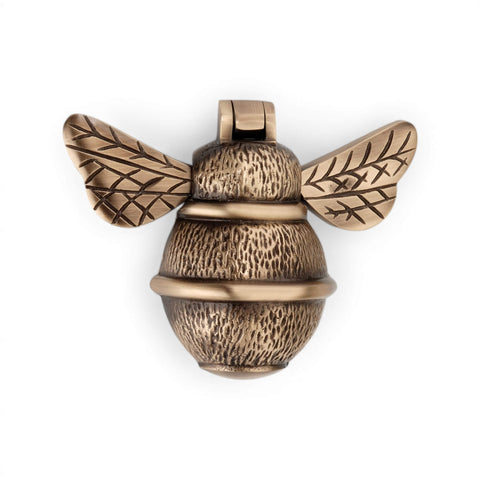 Antique brass bumble bee door knocker, angled side view highlighting textured body and raised wing detailing.