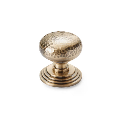 Hammered antique brass cottage centre door knob with stepped circular backplate, front view on white background