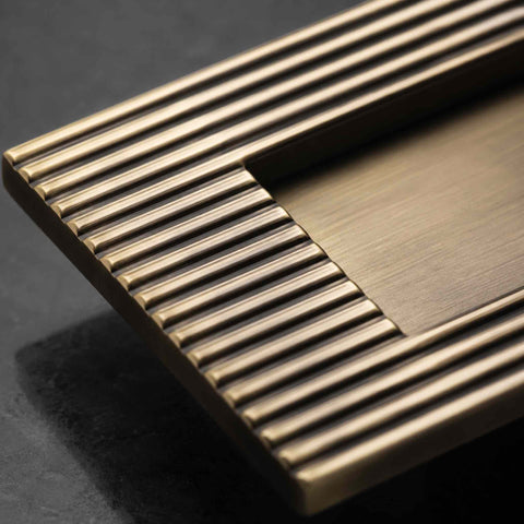 Detailed macro view of reeded antique brass letter plate corner and flap