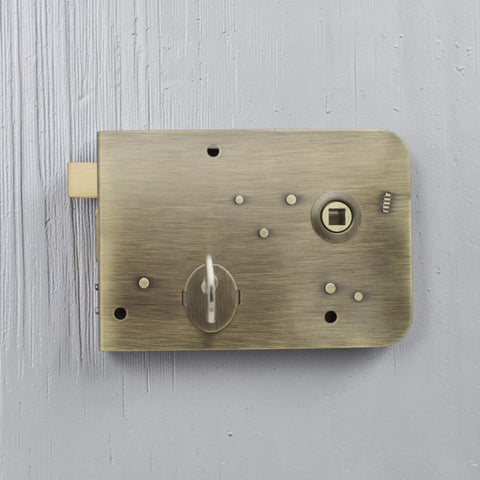 Antique brass rim lock installed on painted timber door