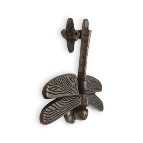 Side view of antique Dragonfly Door Knocker on white background