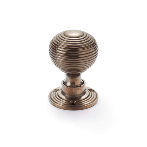 Single antique reeded beehive mortice door knob on round rose backplate.