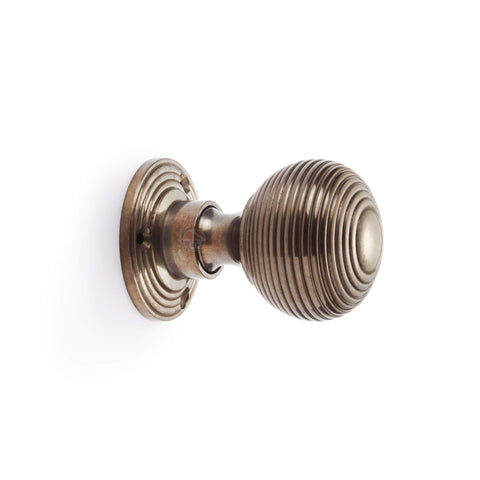 Side profile view of antique reeded beehive rim mortice door knob with circular backplate.