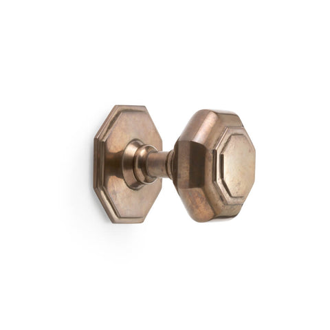 Unlacquered antique octagonal centre door knob, side profile showing projection and tiered base on white background.