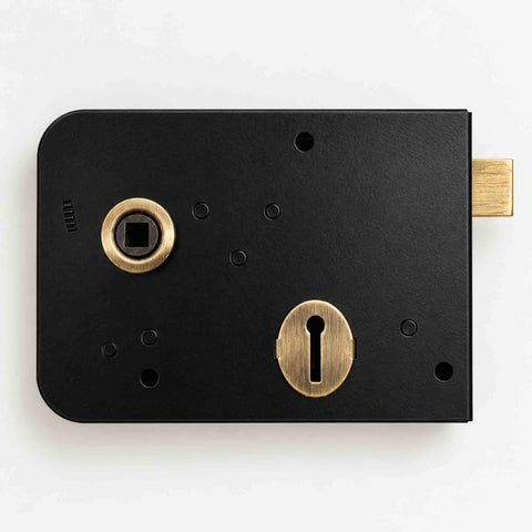 Front view of black and antique brass left hand Scotch rim lock showing antique brass latch, keyhole and handle follower