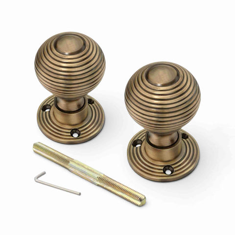 Pair of 50mm antique brass reeded beehive door knobs with threaded spindle and Allen key