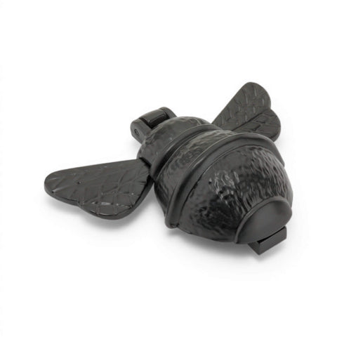 Black cast iron bumble bee door knocker angled side view highlighting curved body and wing detail