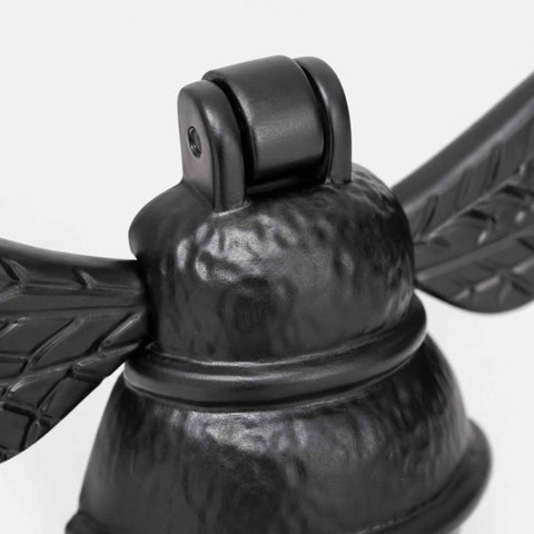 Close-up of black cast iron bumble bee door knocker showing textured cast finish