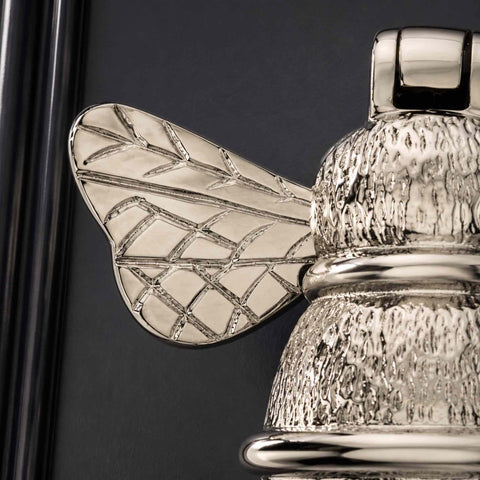 Macro view of polished nickel bumble bee door knocker highlighting engraved wing detailing and polished nickel finish