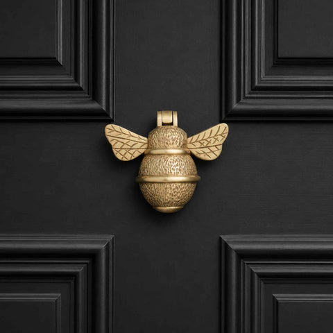 Satin Brass Bumble Bee Door Knocker displayed on a black panelled front door, showcasing the warm brushed brass finish.