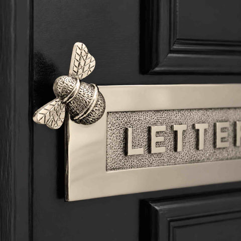 1. Close-up of polished nickel Bumble Bee “LETTERS” letter plate showing detailed bee design and textured raised lettering on a black front door