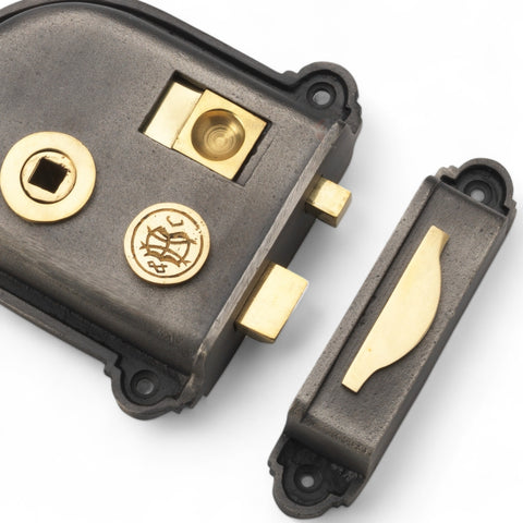 lose-up view of a Cromwell cast iron rim lock showing brass latch, spindle hole, and decorative brass detailing