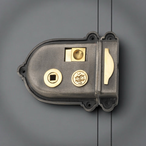 Cromwell cast iron rim lock with brass latch and fittings mounted on a painted timber door.