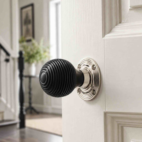 Ebonised beehive door knob with polished nickel backplate fitted to a white panelled interior door