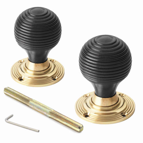 Pair of ebonised black beehive rim mortice door knobs with unlacquered polished brass backplates, supplied with threaded spindle and Allen key.