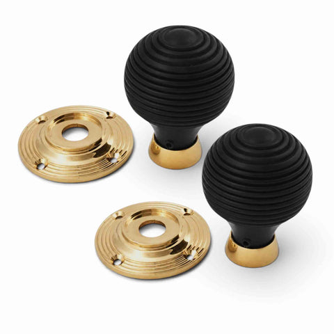 Ebonised black beehive door knobs with removable unlacquered polished brass backplates, shown disassembled to display the separate knob and rose components.
