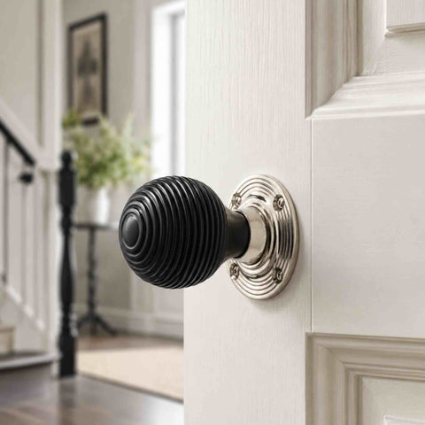 Ebonised black beehive door knob with polished nickel reeded backplate fitted to a white panelled interior door