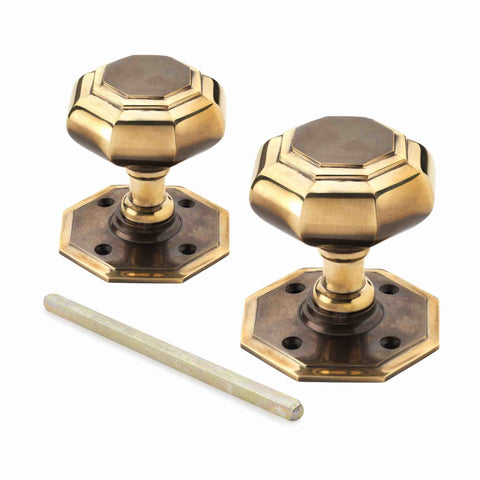 Pair of large 70mm aged brass octagonal mortice door knobs with matching backplates and spindle.