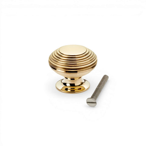 Aged brass beehive cupboard knob with fixing screw, solid brass cabinet knob with reeded design on white background