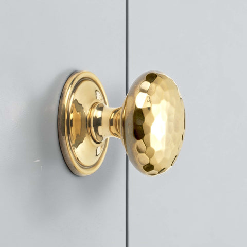 38mm solid aged brass hammered cupboard knob with plain backplate fitted to grey cabinet door