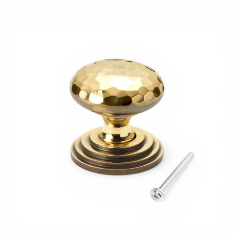 38mm solid aged brass hammered cupboard knob with stepped backplate and fixing screw on white background
